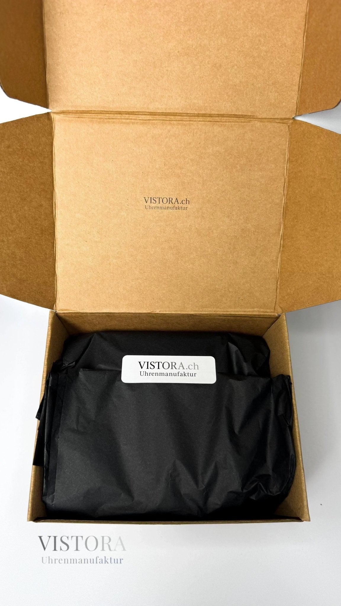 Verpackung der Vistora Uhrenmanufaktur mit eigenem Design und sorgsam verpackter Uhr.
Geöffnete Versandbox der SeikoMod Santos mit Vistora Aufbewahrungsbeutel.