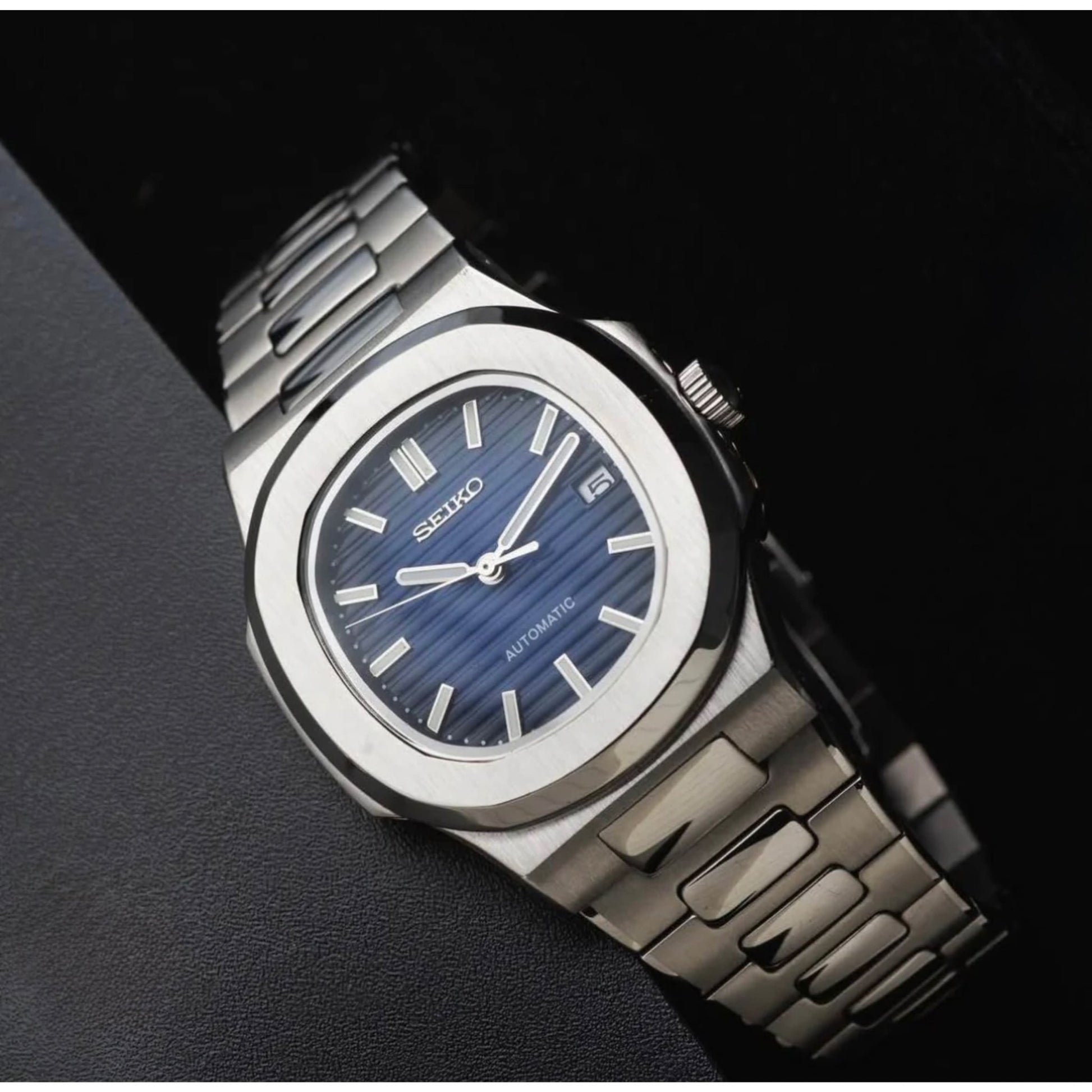 Minimalistische Produktaufnahme der SeikoMod Nautilus Silber mit blauem Zifferblatt, integriertem Armband und luxuriösem Design inspiriert von ikonischen Sportuhren.