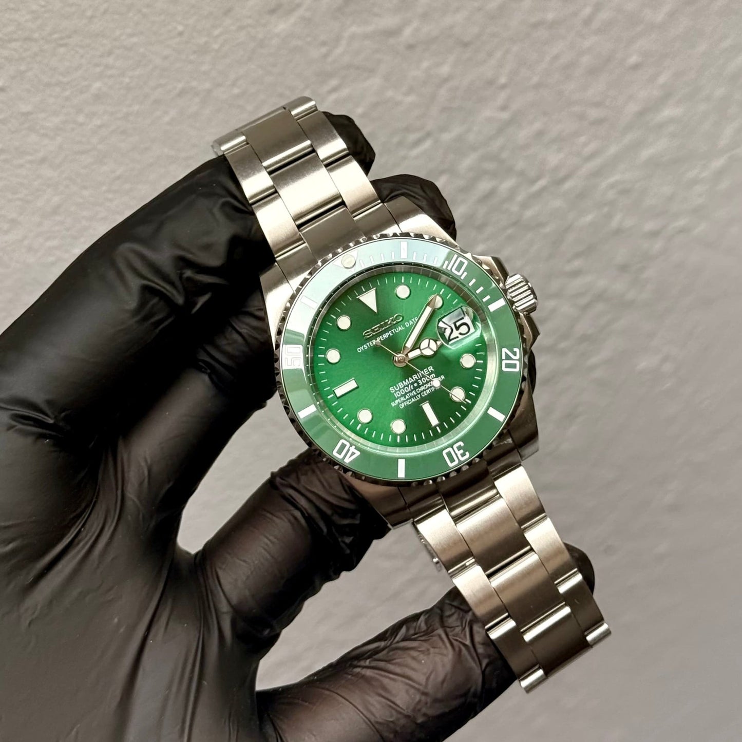 SeikoMod Submariner Hulk in behandschuhter Hand bei der Qualitätsprüfung mit grüner Lünette und Zifferblatt