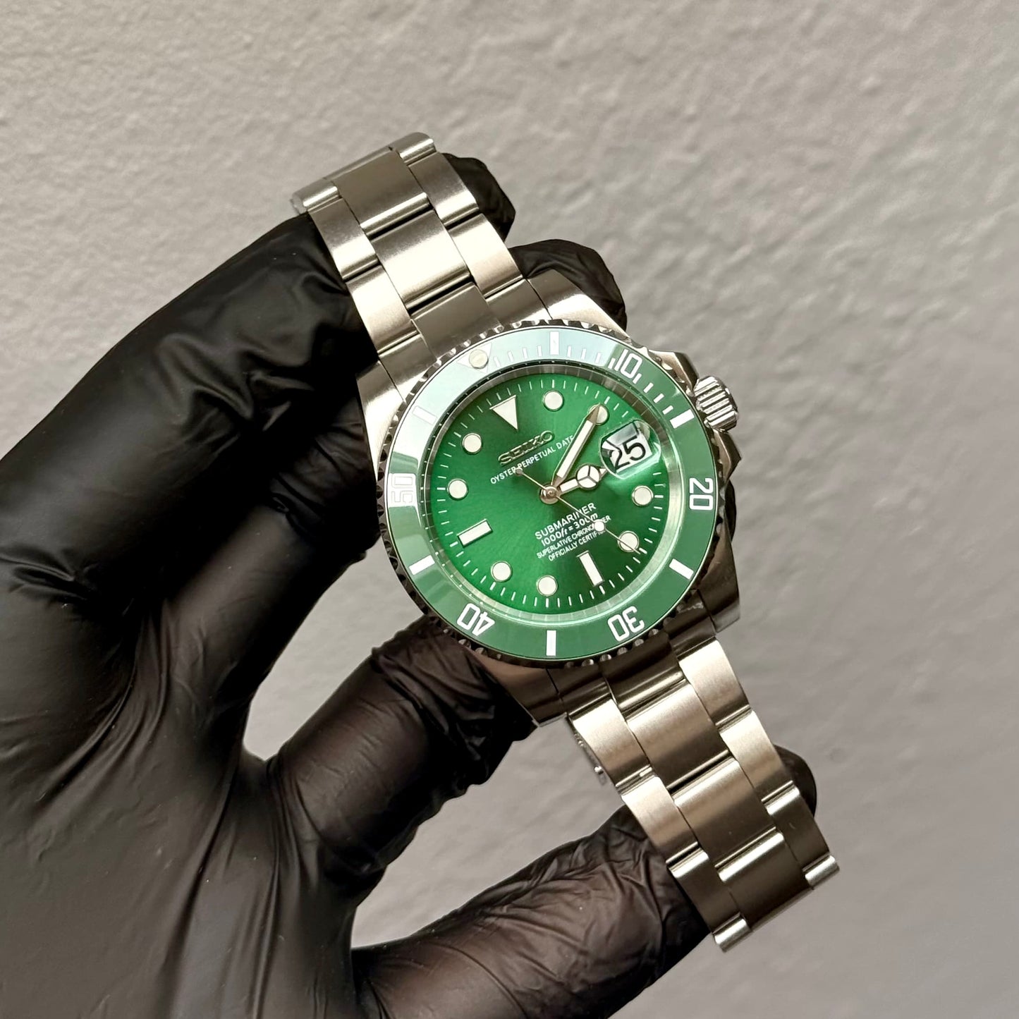 SeikoMod Submariner Hulk in behandschuhter Hand bei der Qualitätsprüfung mit grüner Lünette und Zifferblatt