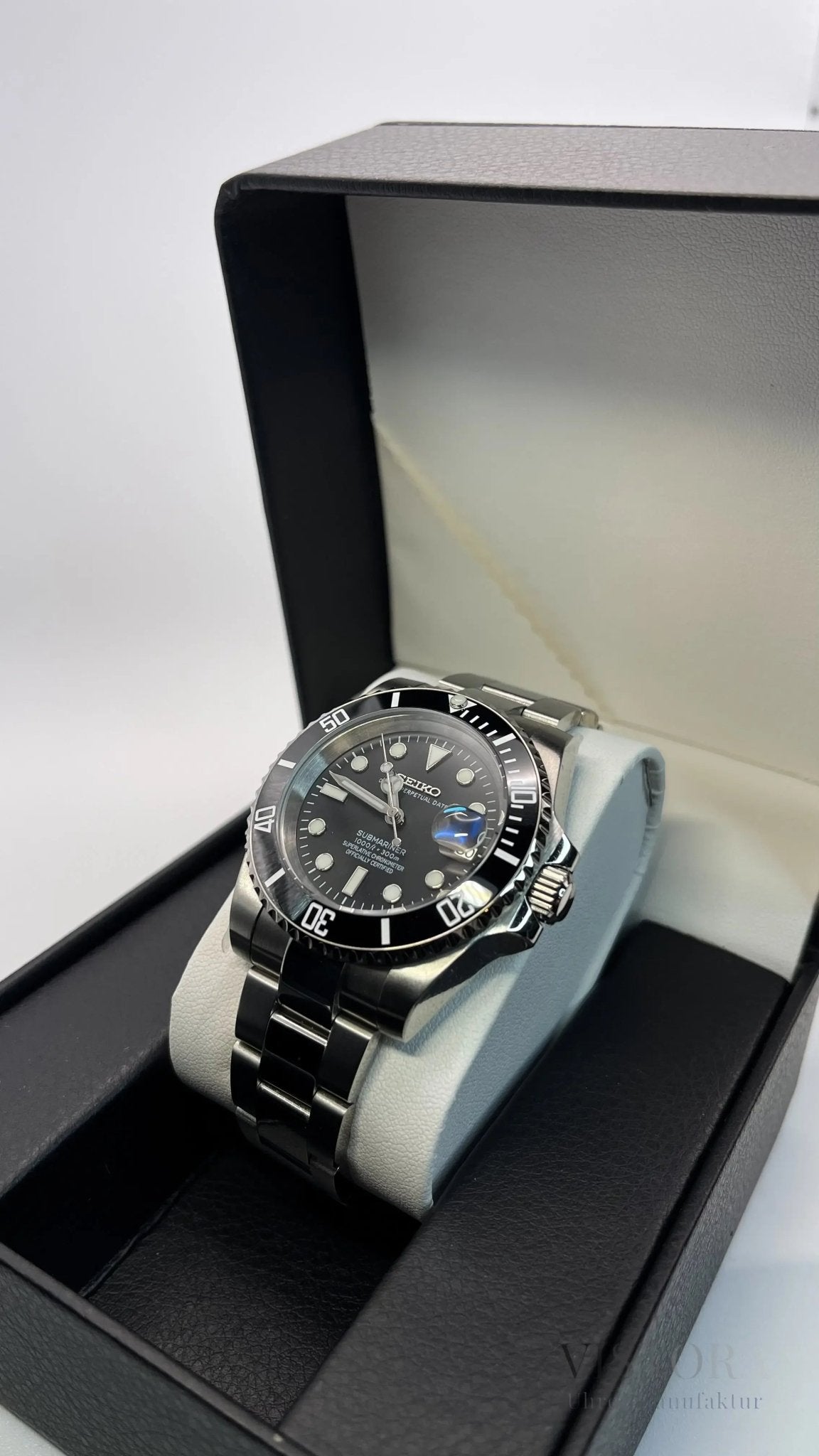 SeikoMod Submariner Schwarz in Präsentationsbox, poliertes Armband im Winkel sichtbar
